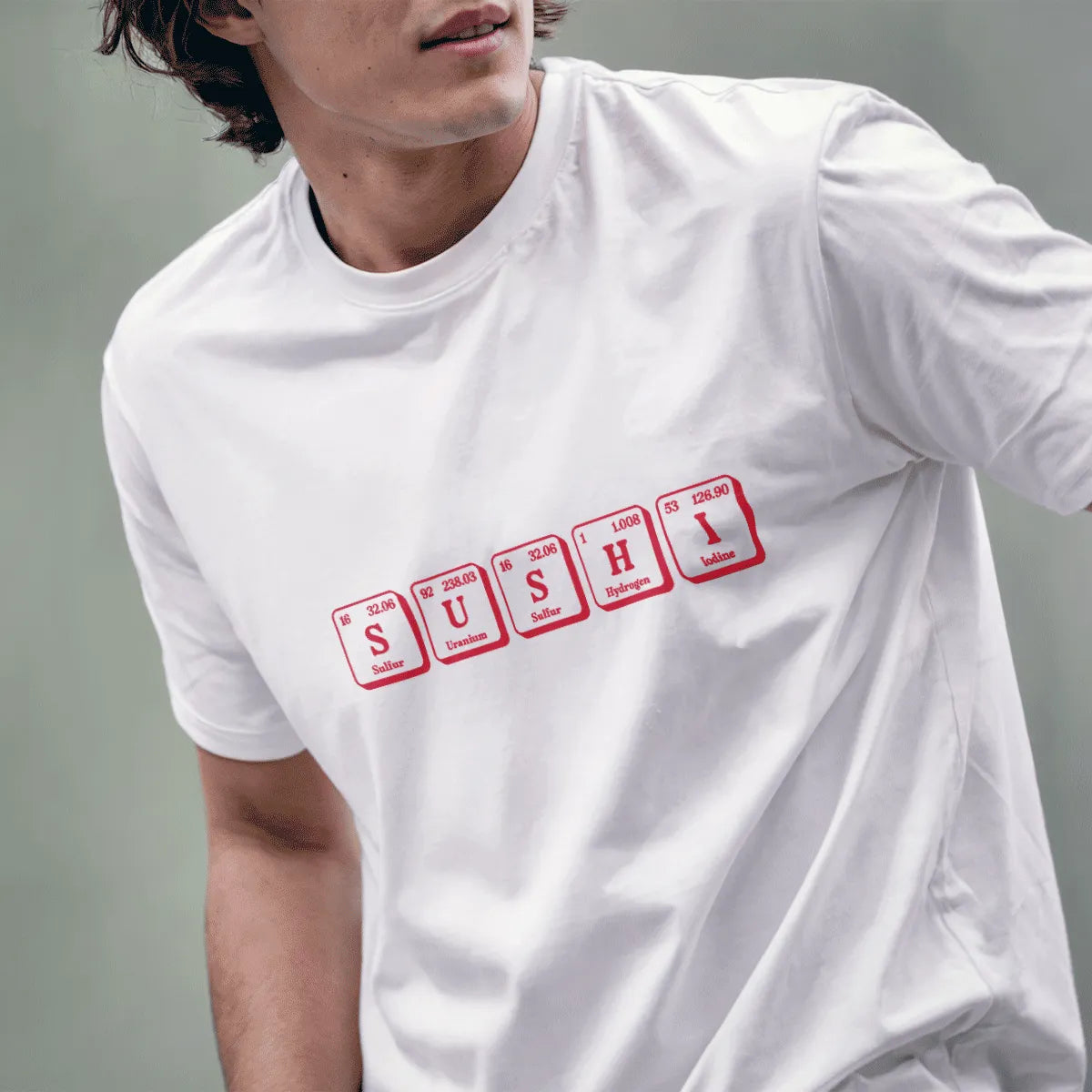 Male model wearing white sushi shirt with periodic table-inspired "SUSHI" elements in bold red text.