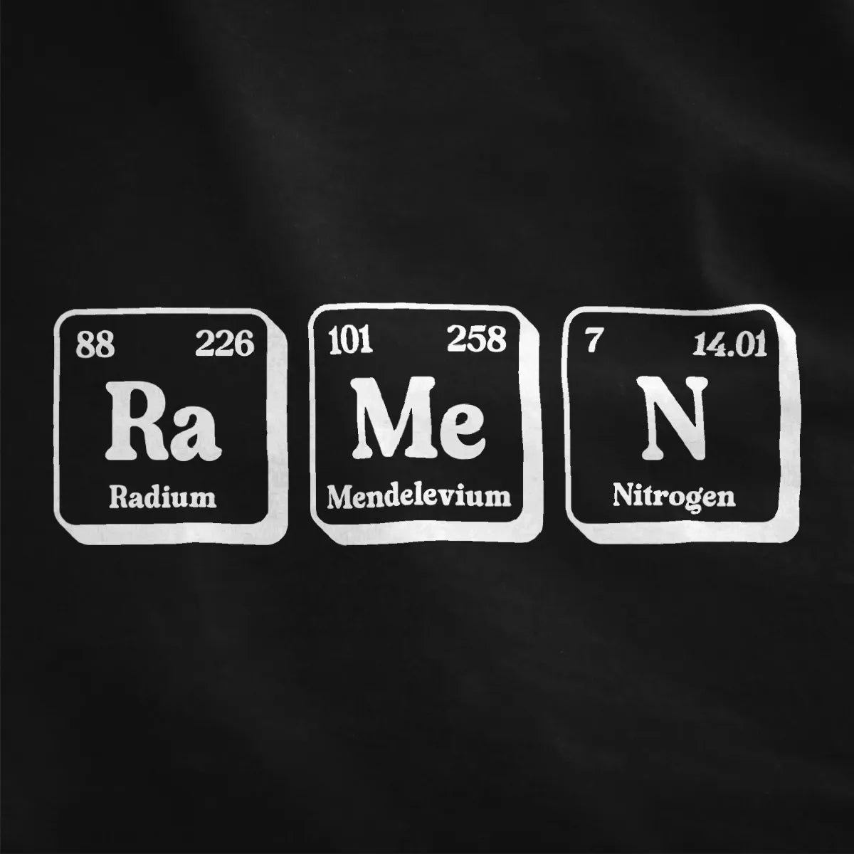 Close-up of red and white periodic table ramen shirt on black fabric, highlighting contrast art and bold text fonts.