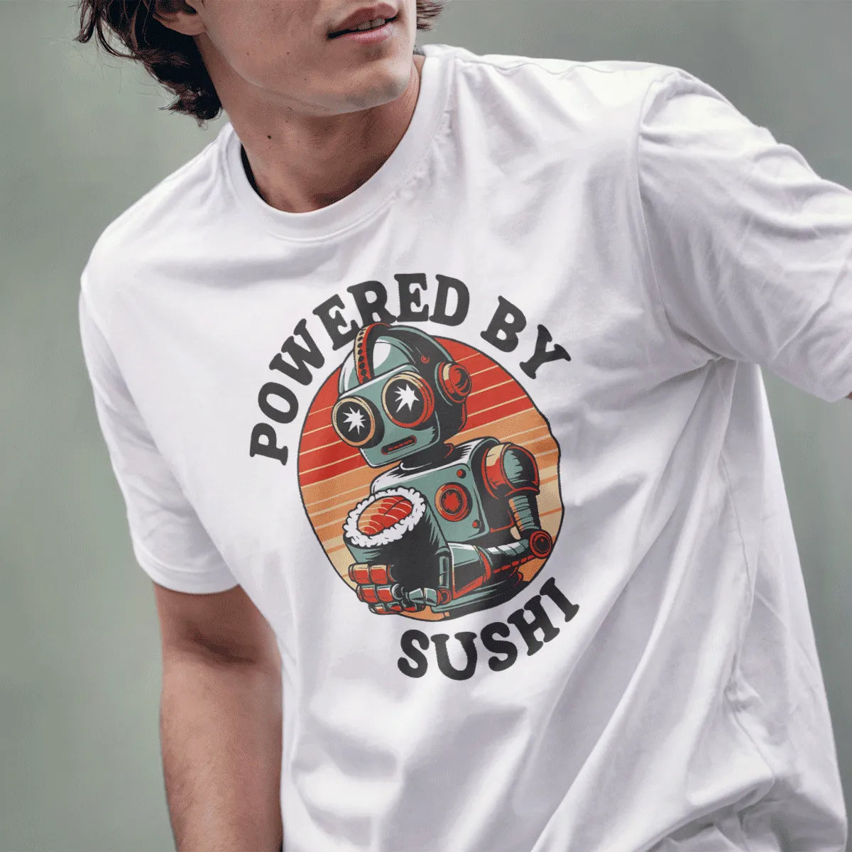 Male model wears white t-shirt with retro robot and sushi roll, curved “POWERED BY SUSHI” text, quirky shirt.