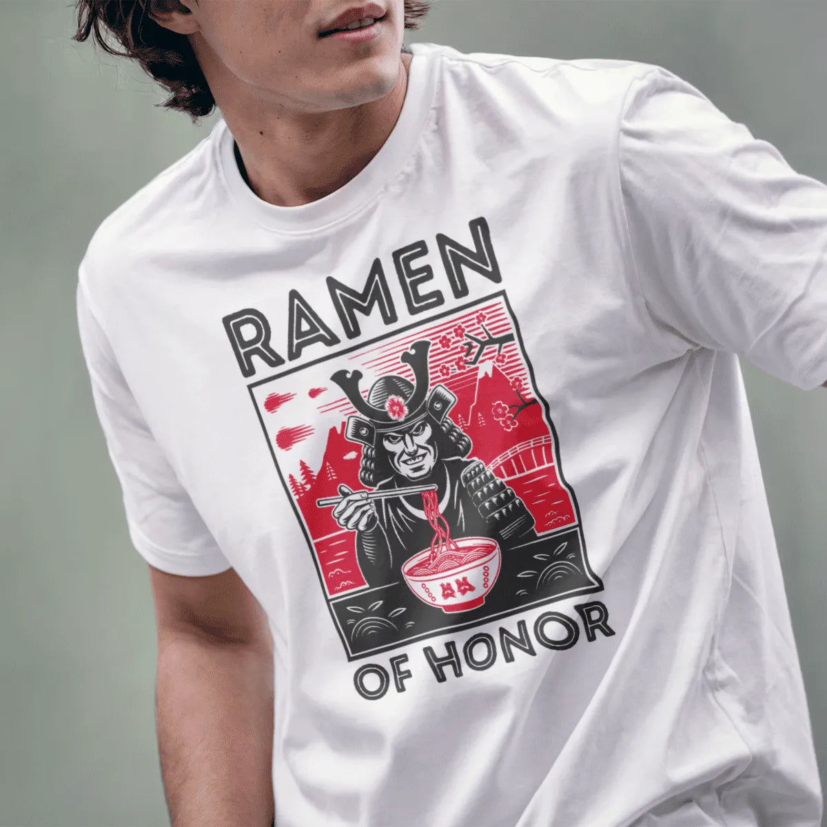 Male model in white t-shirt featuring samurai eating ramen, red landscape, and bold text; ramen t-shirt.