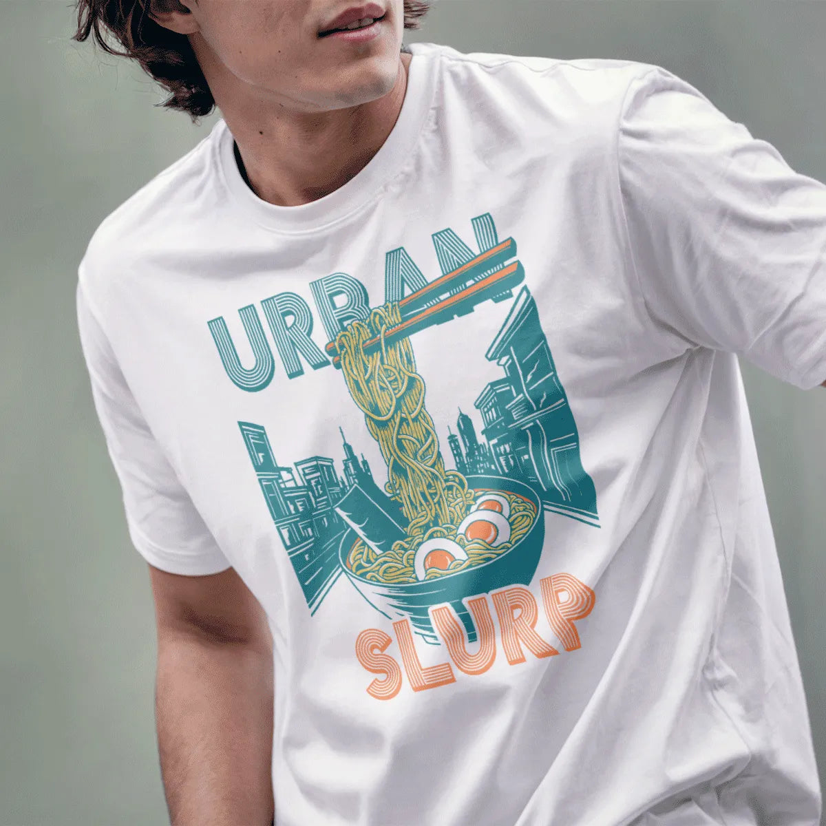 Male model in white t-shirt with ramen bowl, teal cityscape, and "URBAN SLURP" text, japanese t-shirts.