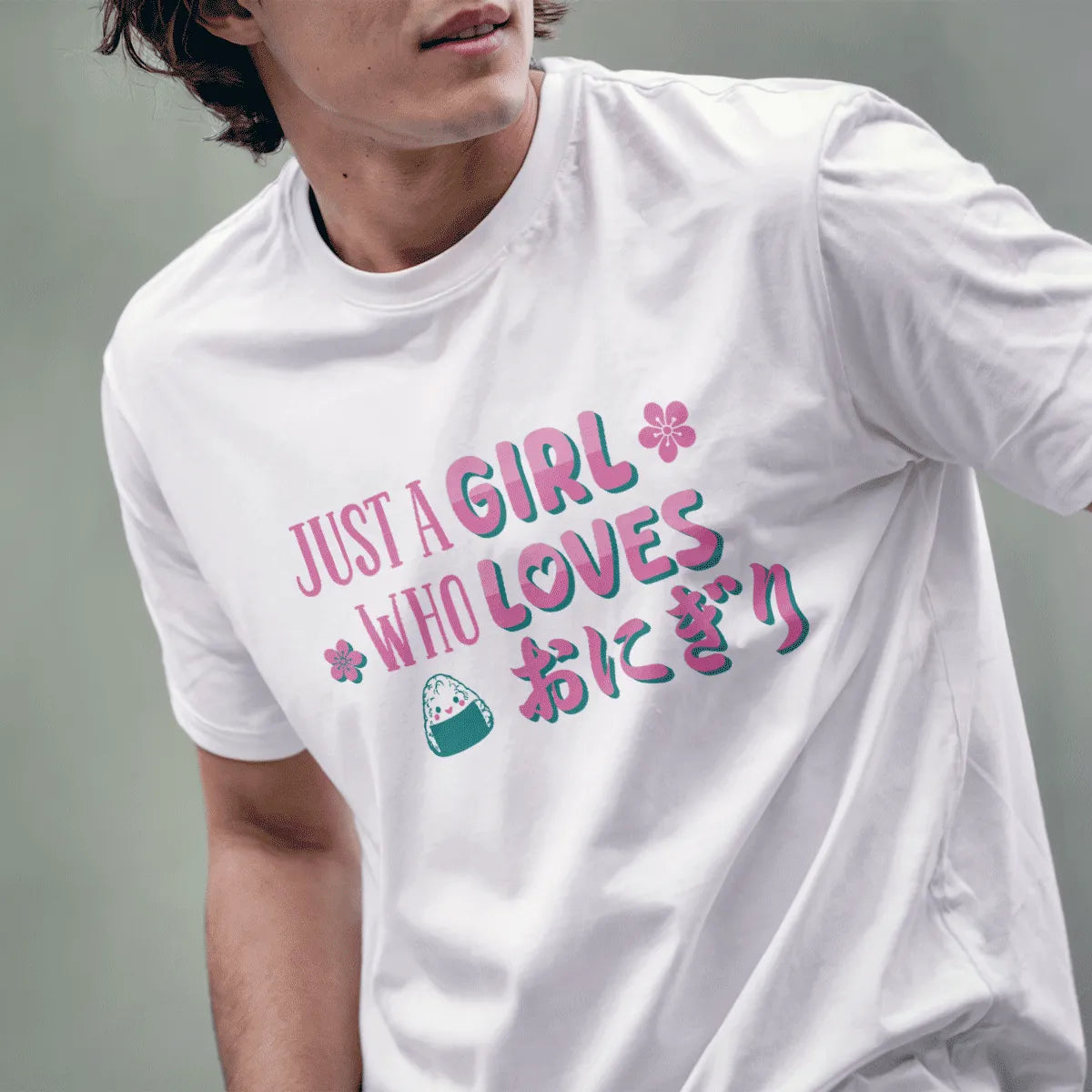 Male model wears white tee with cute onigiri, pink cherry blossoms, and teal Japanese text, t shirt design graphic.