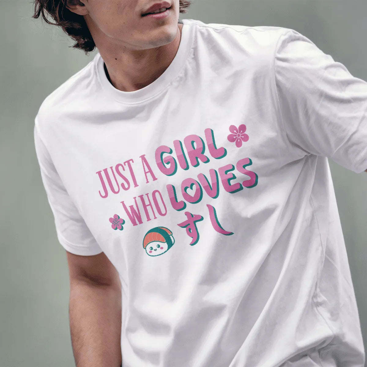 Male model wears white tee with playful sushi graphic, pink and teal text, and flowers, sushi shirt, japanese t-shirts.