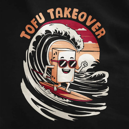 Close-up of whimsical tofu surfing illustration on black shirt, with vibrant style and dynamic ocean wave.