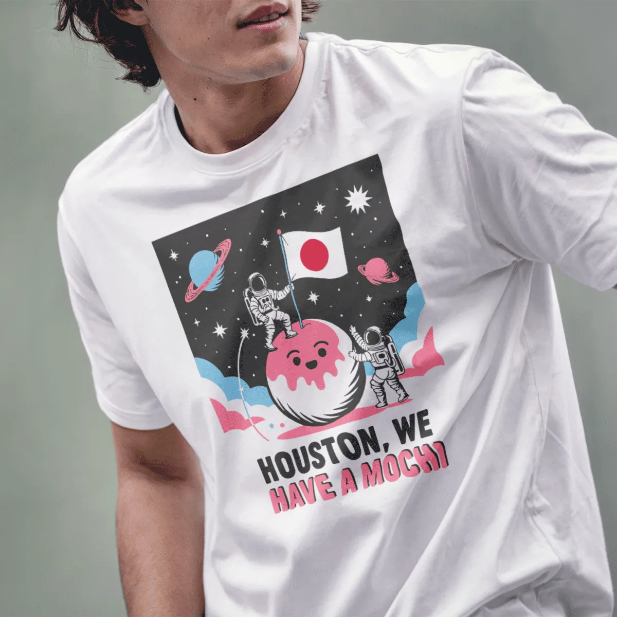 Male model in white t-shirt with playful mochi planet, astronauts, and Japanese flag, space shirt.