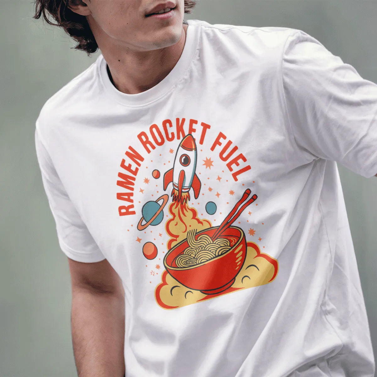 Male model in white t-shirt with ramen bowl, rocket, and dynamic retro typography, space-themed food.