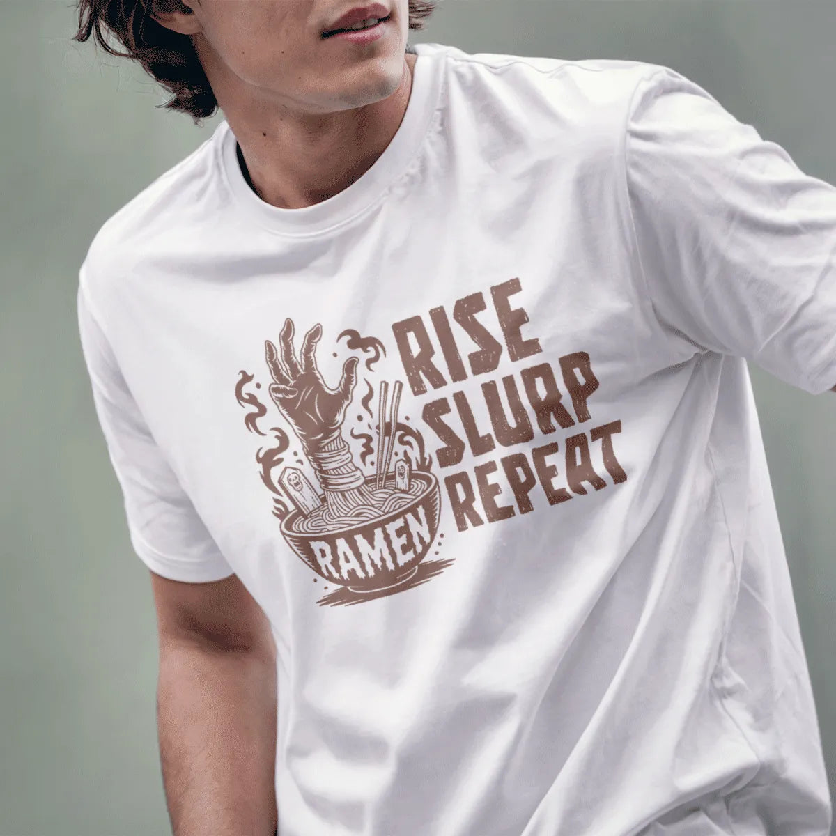 Male model in white shirt with zombie hand clutching ramen, bold "RISE SLURP REPEAT" text and gravestones.