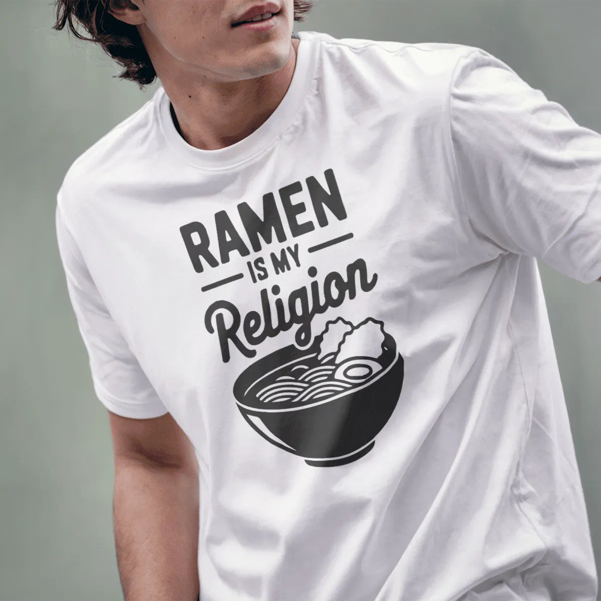 Male model wears white t-shirt with bold RAMEN IS MY Religion typography and minimalist ramen bowl, ramen t-shirt.