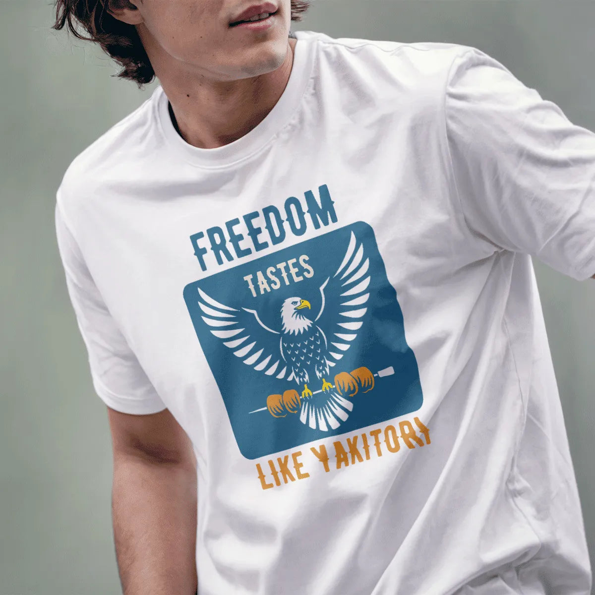 Male model in white t-shirt with eagle, yakitori, bold "FREEDOM TASTES LIKE YAKITORI" text. cultural pride