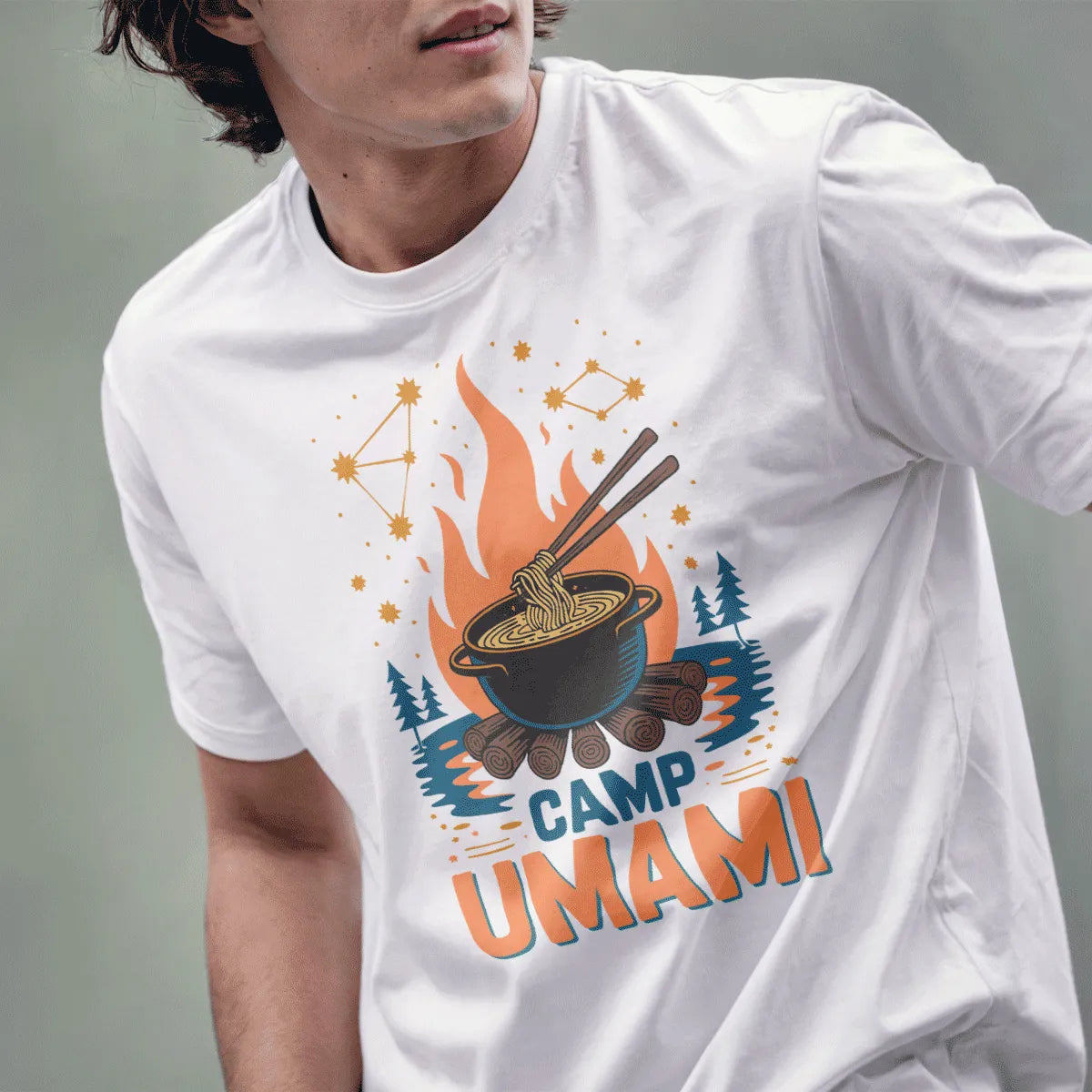 Male model in white Camp Umami t-shirt, noodles lifted by chopsticks, starlit sky, and nature blend.