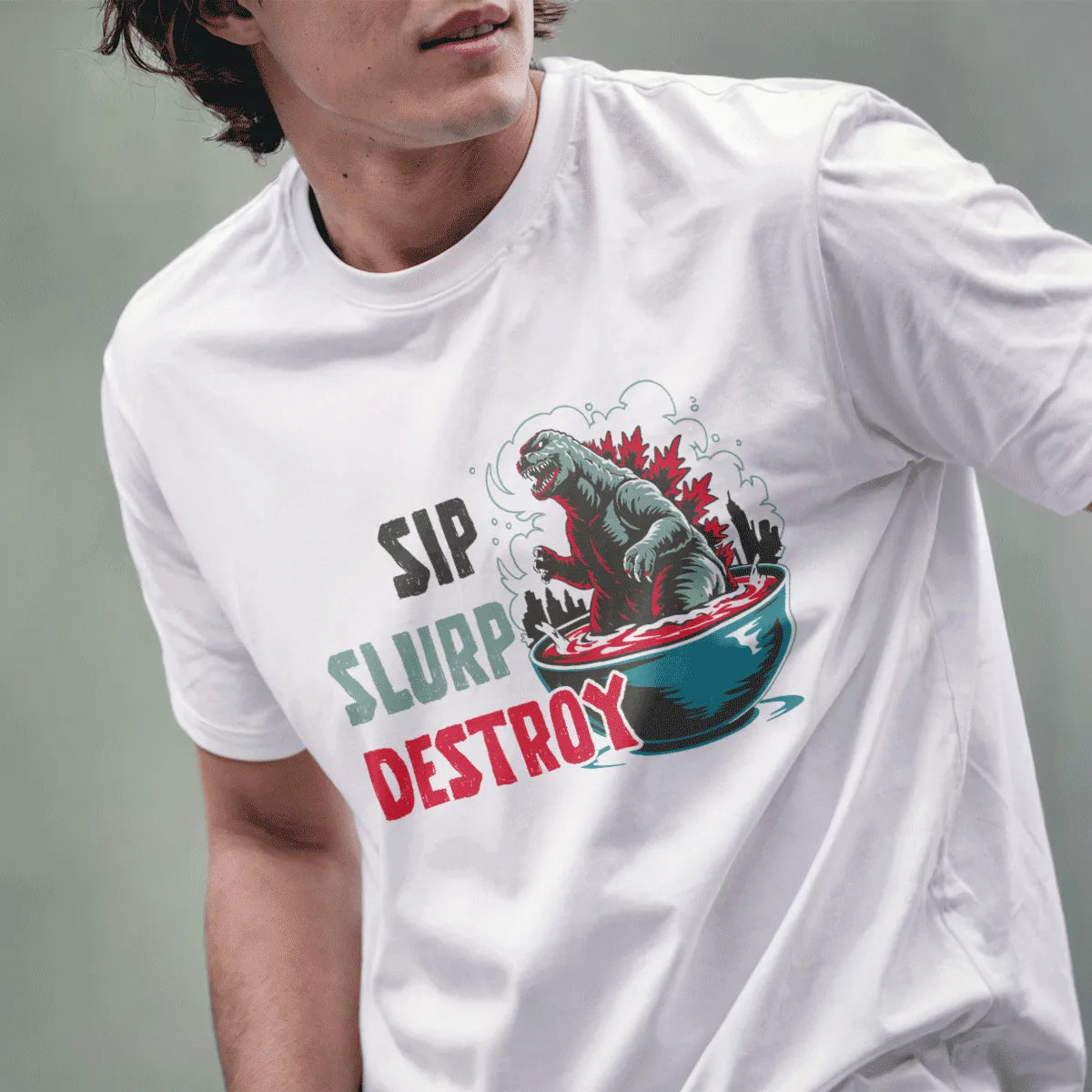 Male model in white t-shirt with ramen Godzilla, city skyline, and playful phrase, pop culture, godzilla shirt.