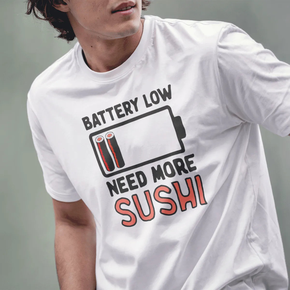 Male model in white shirt with “BATTERY LOW,” battery icon with sushi, “NEED MORE SUSHI” text. japanese t-shirts, sushi pun.