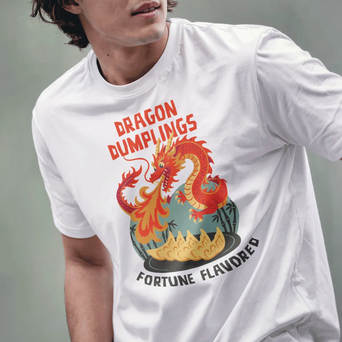Male model wears white t-shirt featuring playful dragon, fortune-flavored dumplings, and retro comic style.
