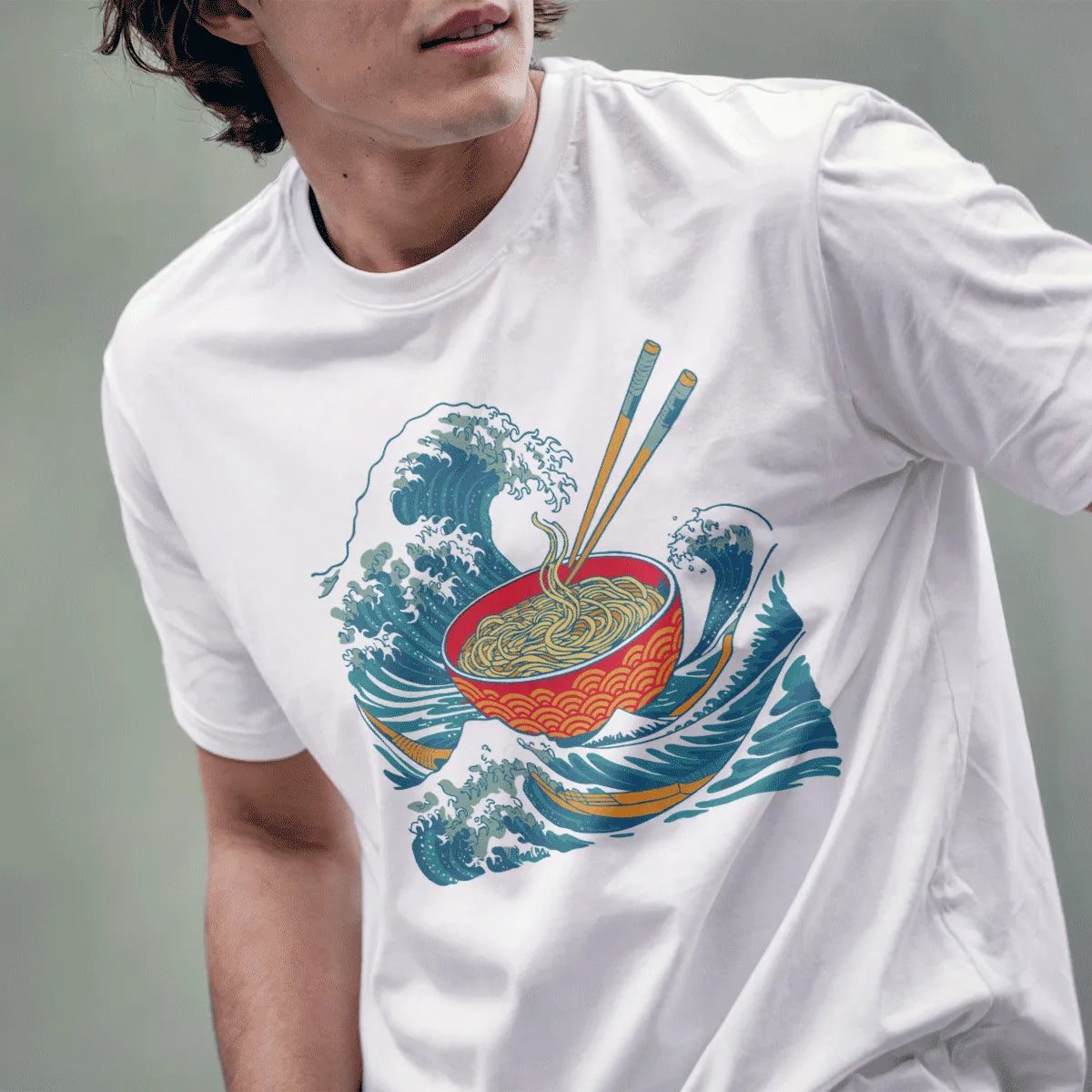 Male model wears white t-shirt featuring graphic ramen bowl, swirling ocean waves, and vintage Japanese style.