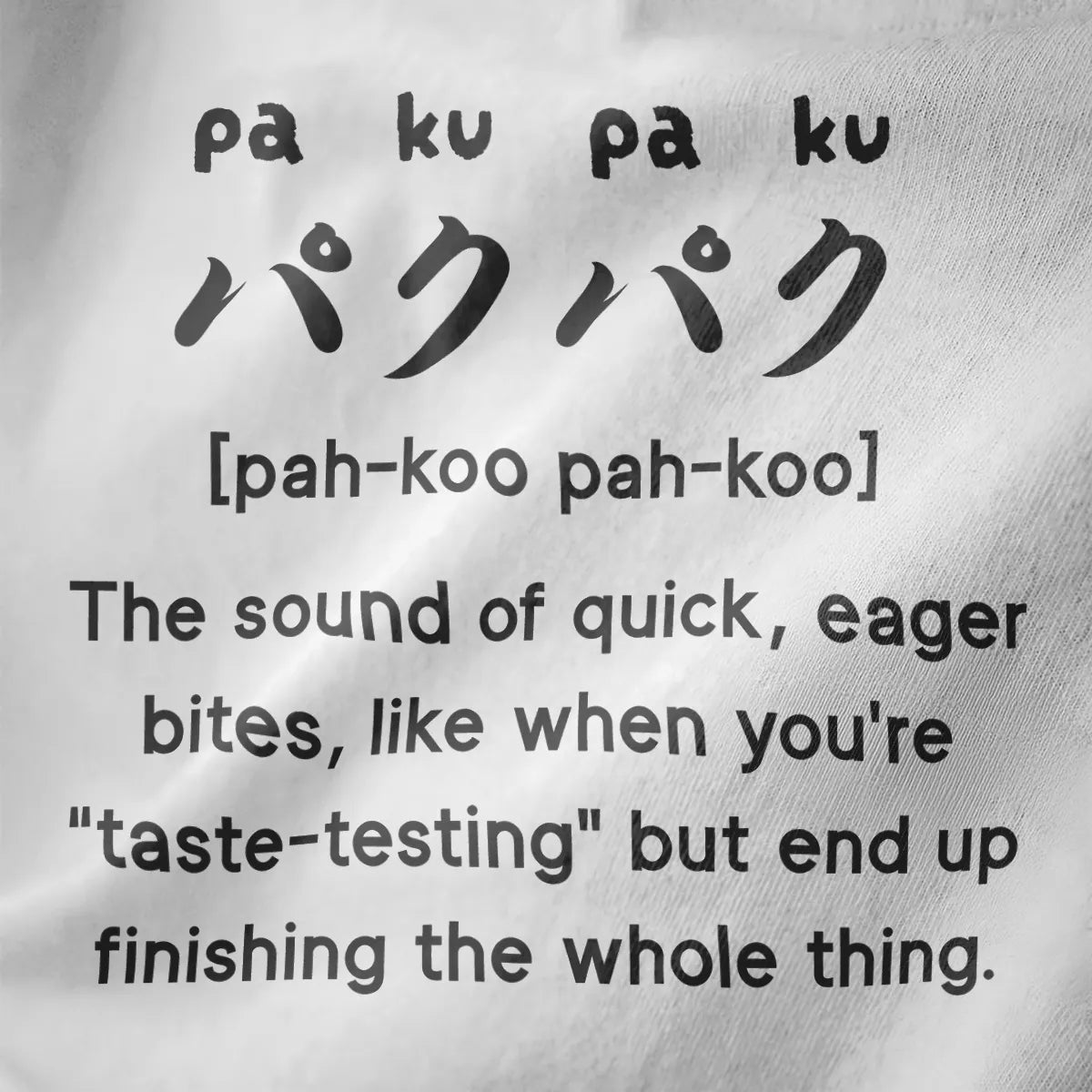 Bold black Japanese "paku-paku" text with English captions on white fabric, funny shirts with sayings, junk food clothing.