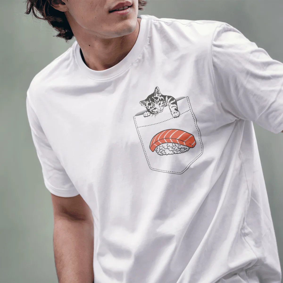 Male model wears white tee featuring cartoon gray kitten resting on pocket above colorful salmon nigiri sushi.