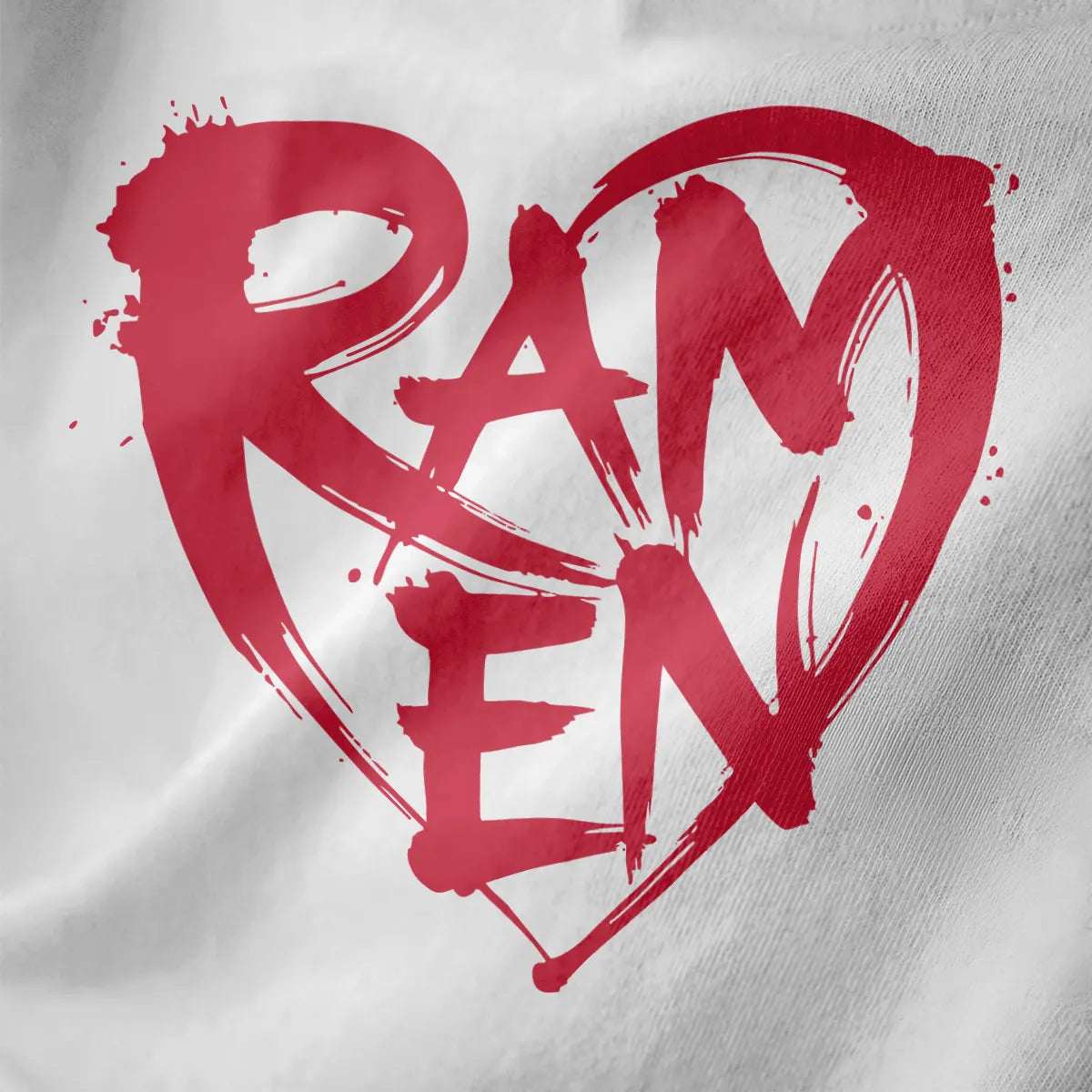 Bold red brushstroke "RAMEN" inside textured heart on white fabric, featuring paint splatter and streetwear feel.