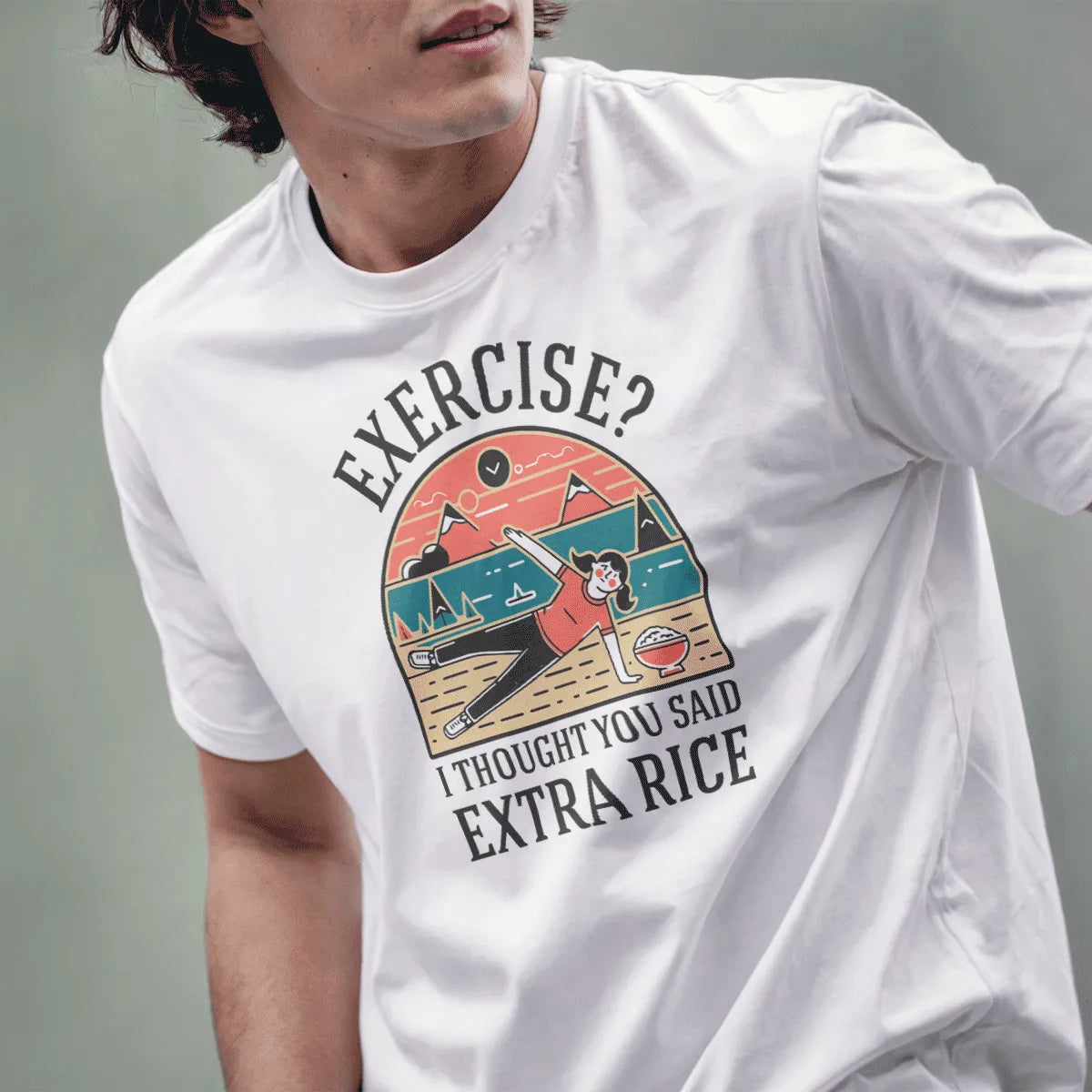 Male model in white t-shirt with humorous "EXERCISE? I THOUGHT YOU SAID EXTRA RICE" graphic and mountain background.