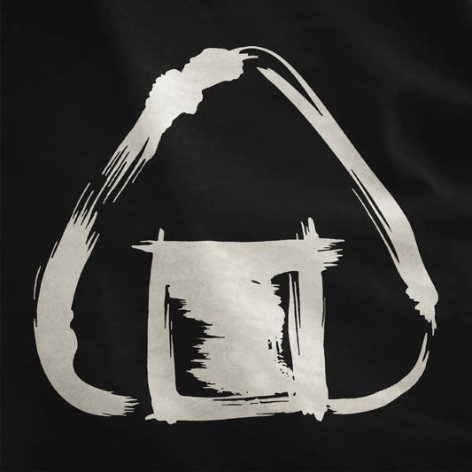 Black fabric close-up showing hand-drawn Japanese onigiri with expressive ink brushwork and stark black-white contrast.