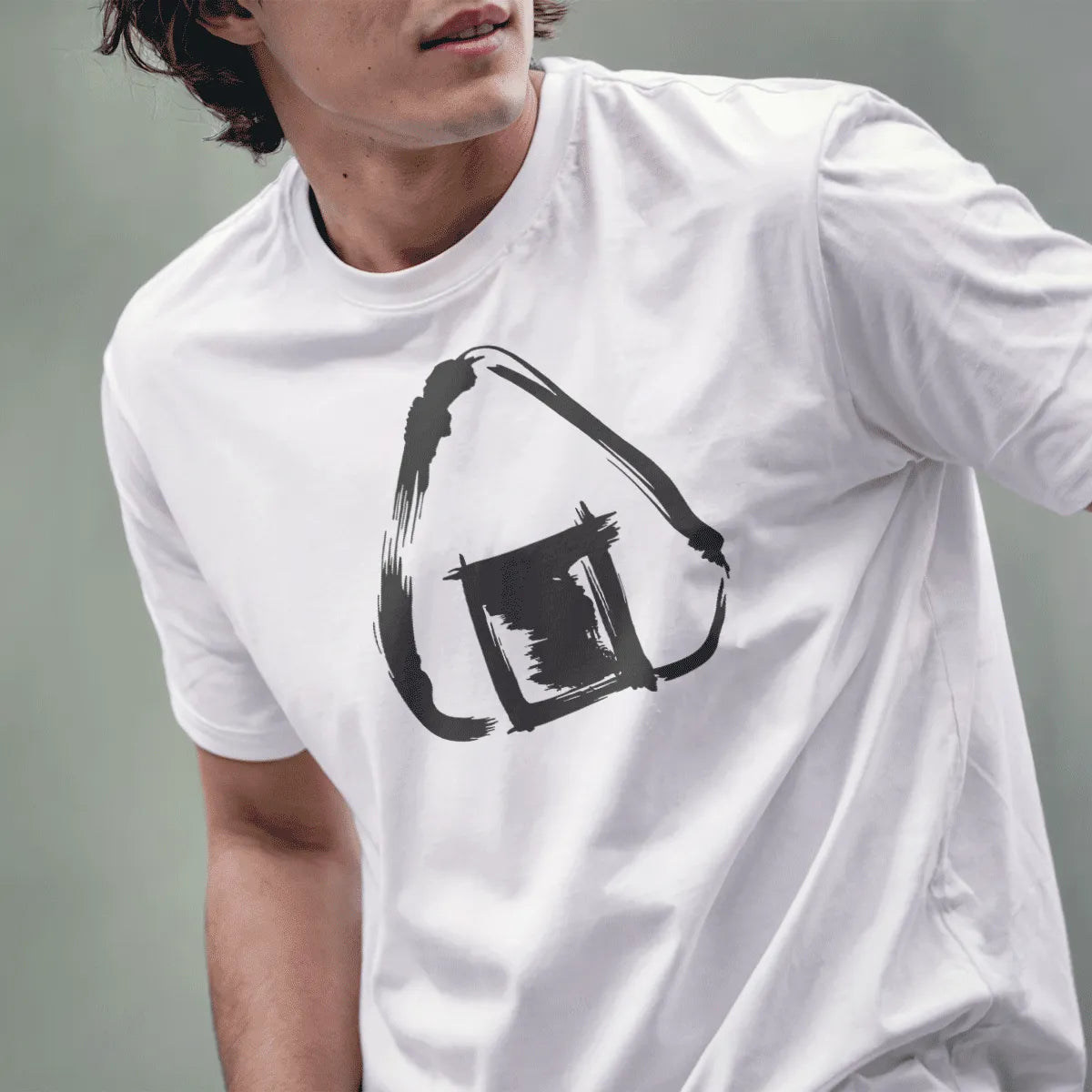 Male model wearing white shirt featuring minimalist line art of triangular rice ball with textured seaweed patch.