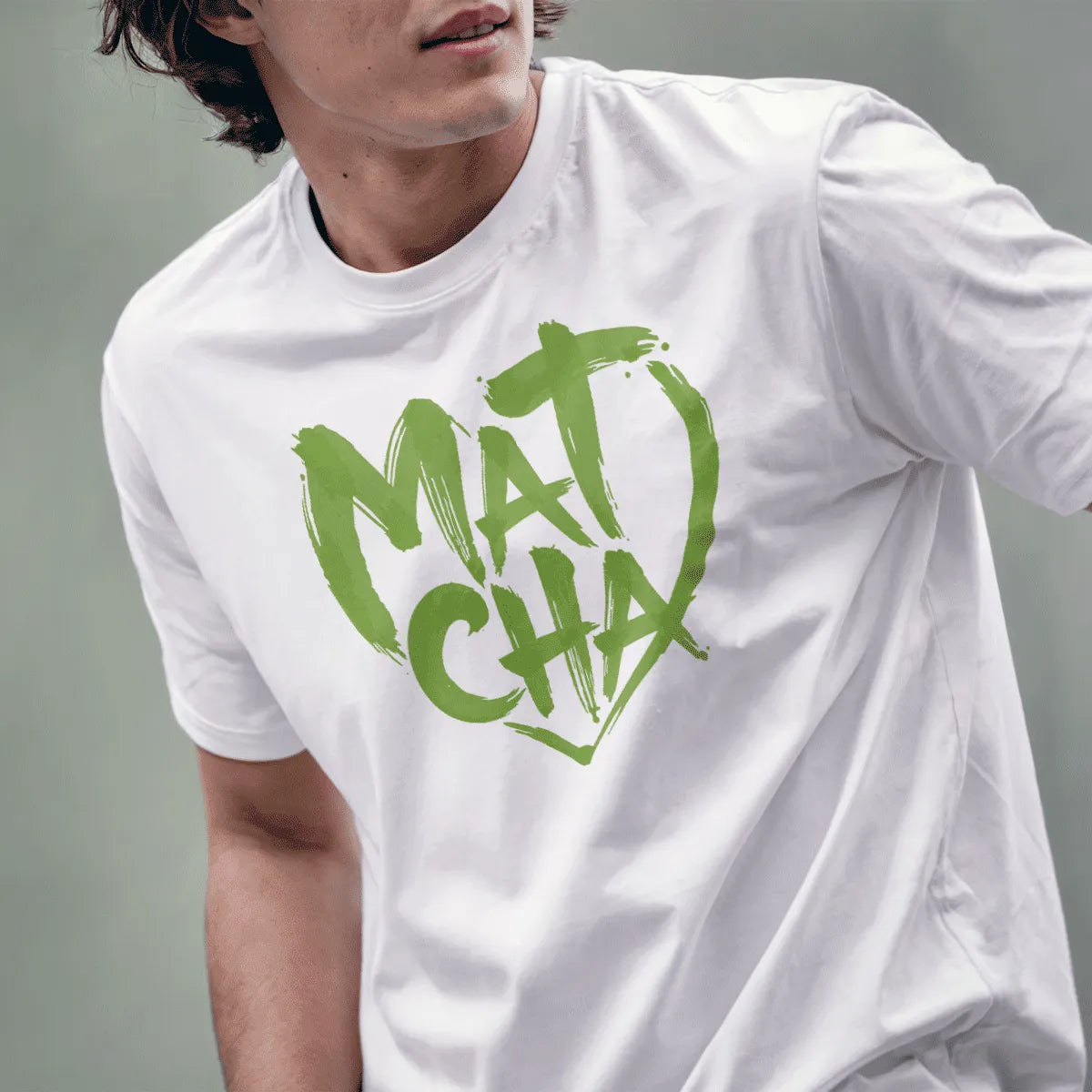 Male model in white tee with bold, playful "Matcha" heart brushstroke design in green.