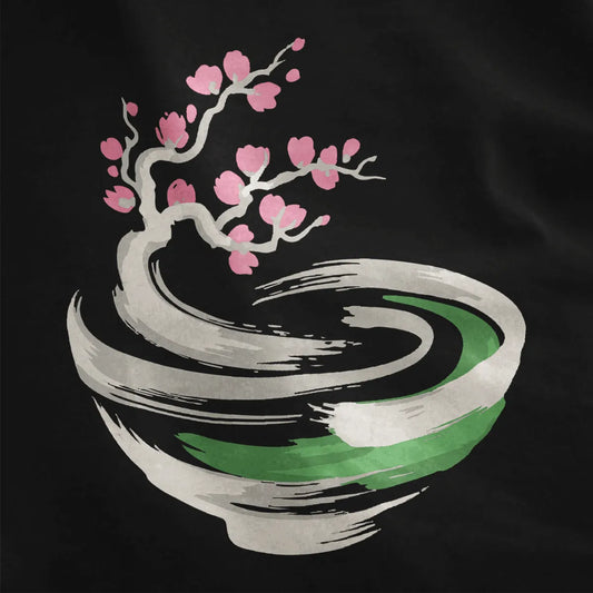 Black fabric close-up featuring elegant pink cherry blossoms arching above a textured brushstroke bowl.