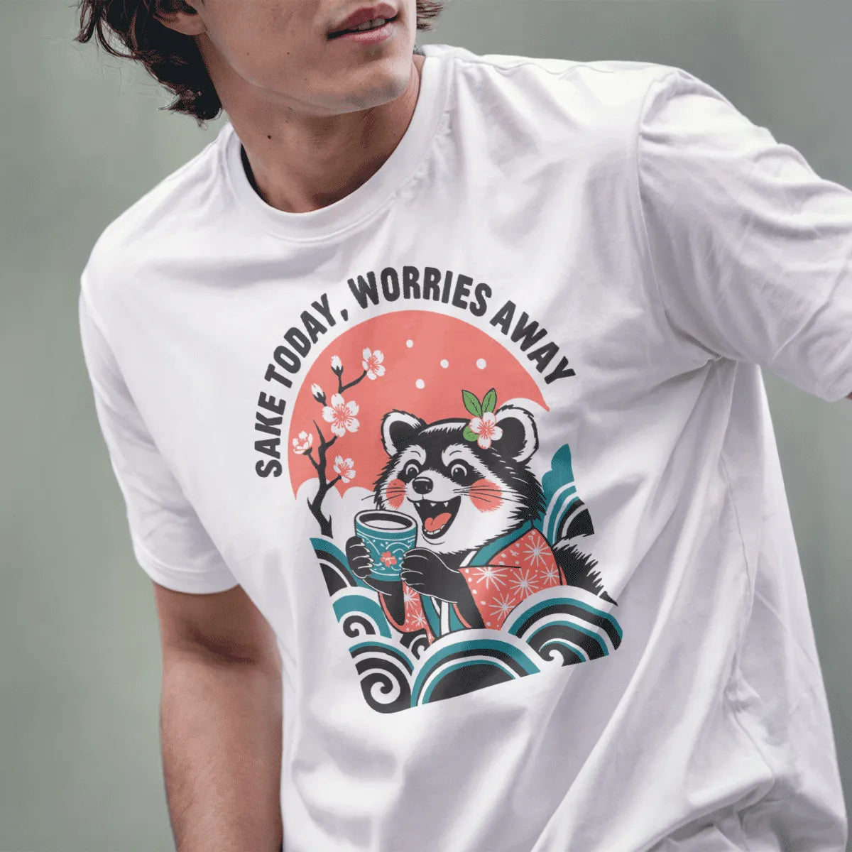 Male model in white tee featuring raccoon holding sake cup, cherry blossom background, calming colors, graphic shirt.