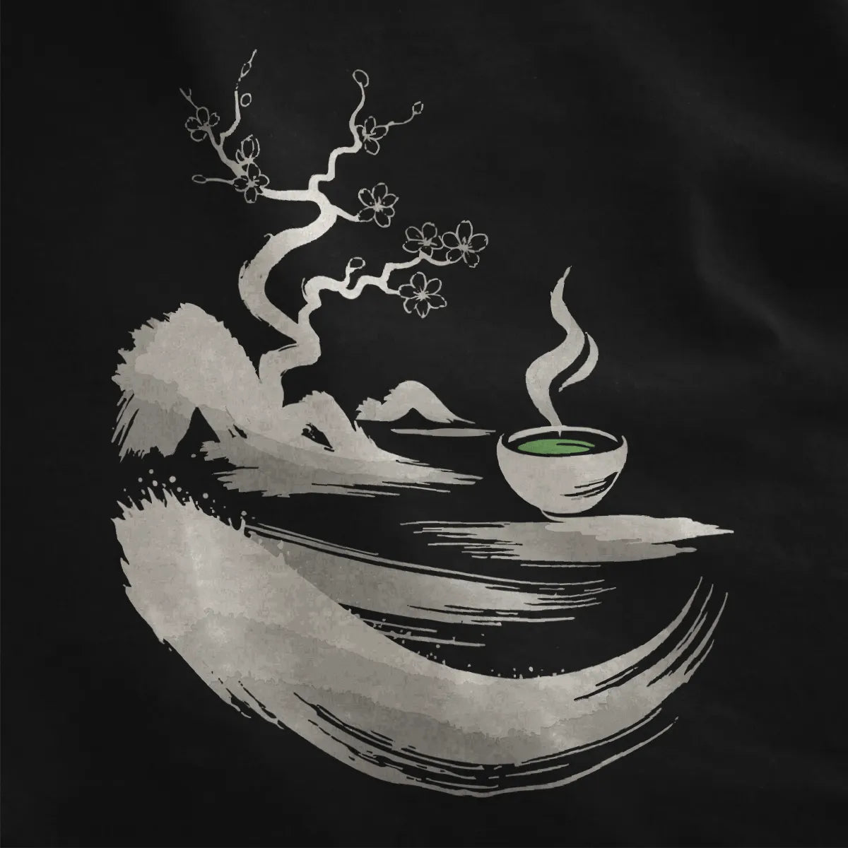 Black fabric close-up showing monochrome sumi-e twisted tree, cherry blossoms, and green matcha bowl.