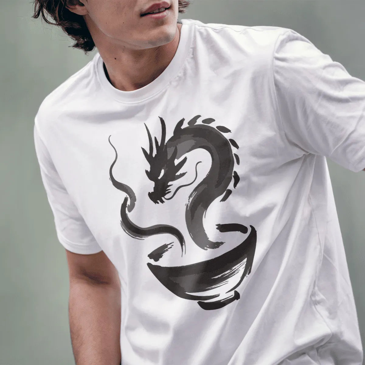 Male model wearing white t-shirt featuring stylized sumi-e dragon and ramen bowl design in dark tones.
