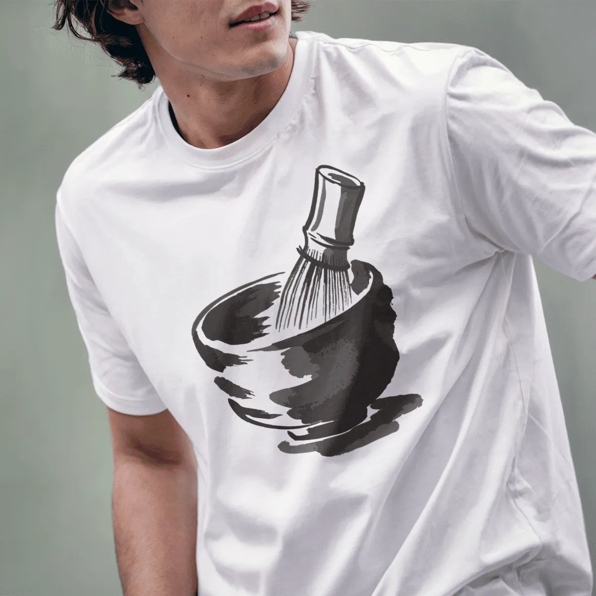 Male model in white t-shirt showing serene matcha tea bowl and bamboo whisk illustration.