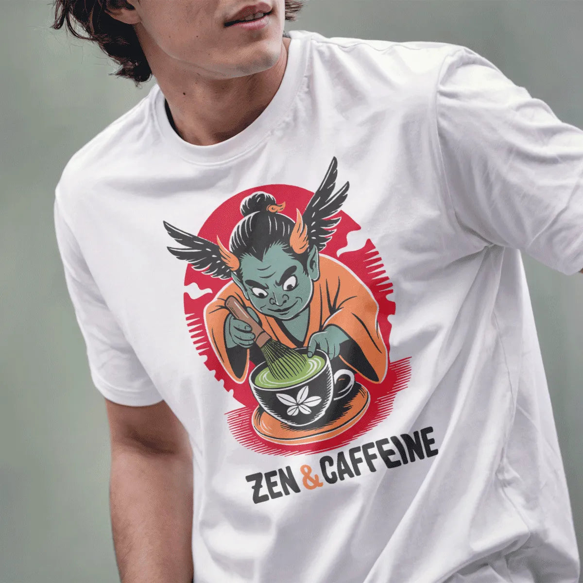 Male model wearing white tee with playful winged teal oni preparing matcha, accented with red sun circle.