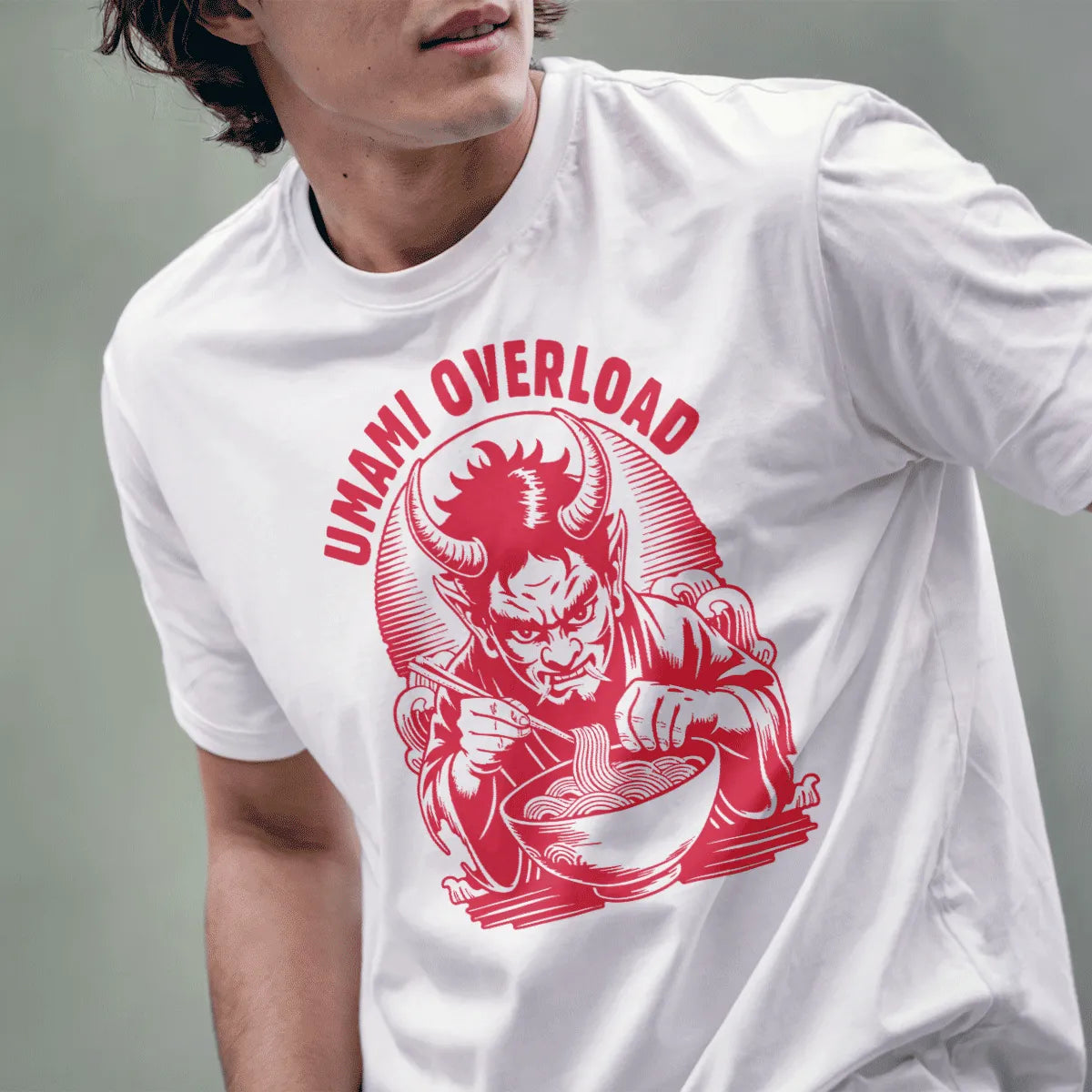 Male model wears white tee with vintage style red oni demon holding ramen bowl, intense umami theme.