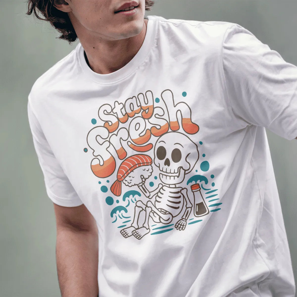 Male model in white t-shirt featuring cartoon skeleton with sushi, retro bubble text, funny shirts with sayings.