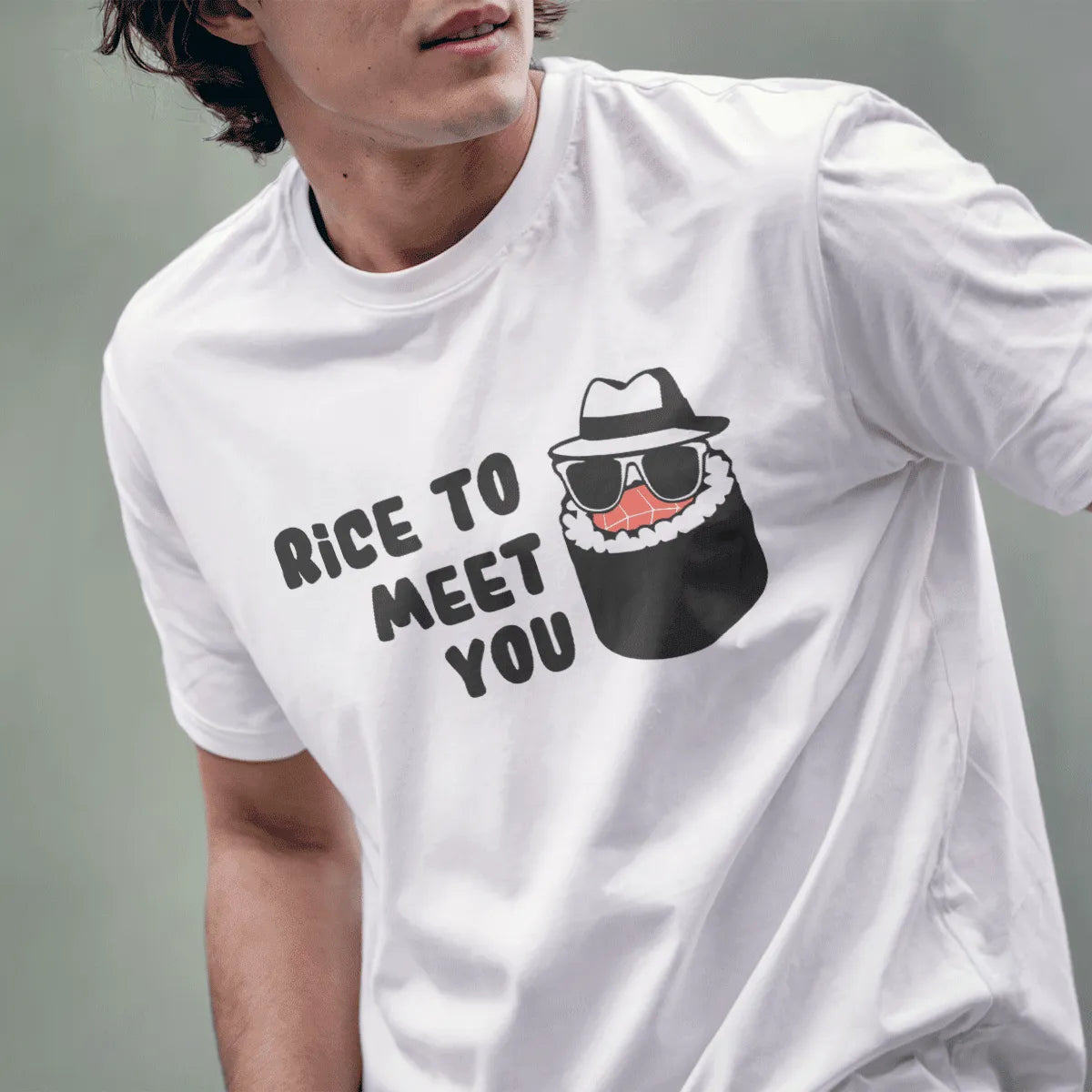 Male model in white t-shirt with cartoon sushi in fedora, sunglasses, and "RICE TO MEET YOU" slogan, modern sushi.