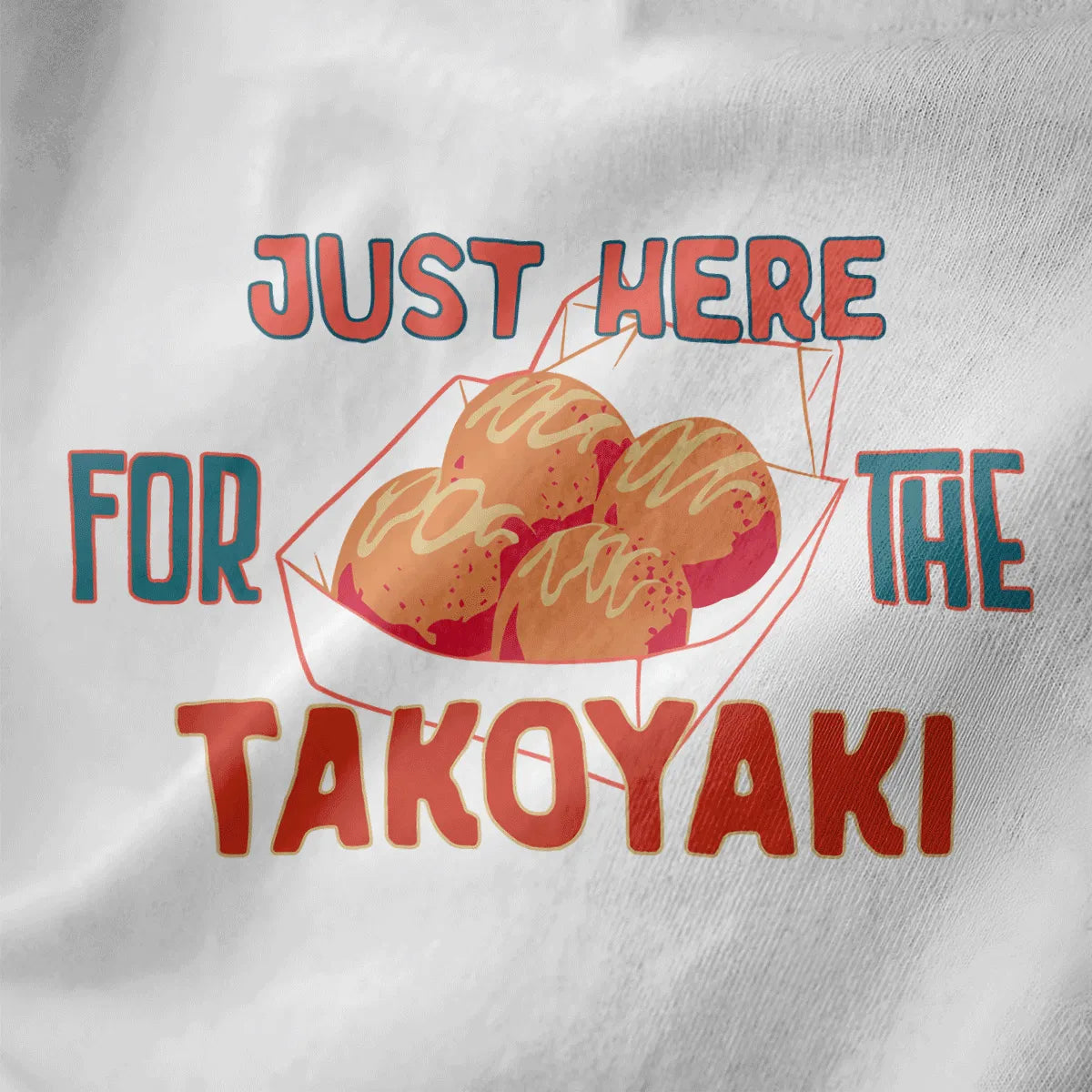 White fabric close-up of takoyaki t-shirt with bold, colorful "JUST HERE FOR THE TAKOYAKI" text, vibrant style.