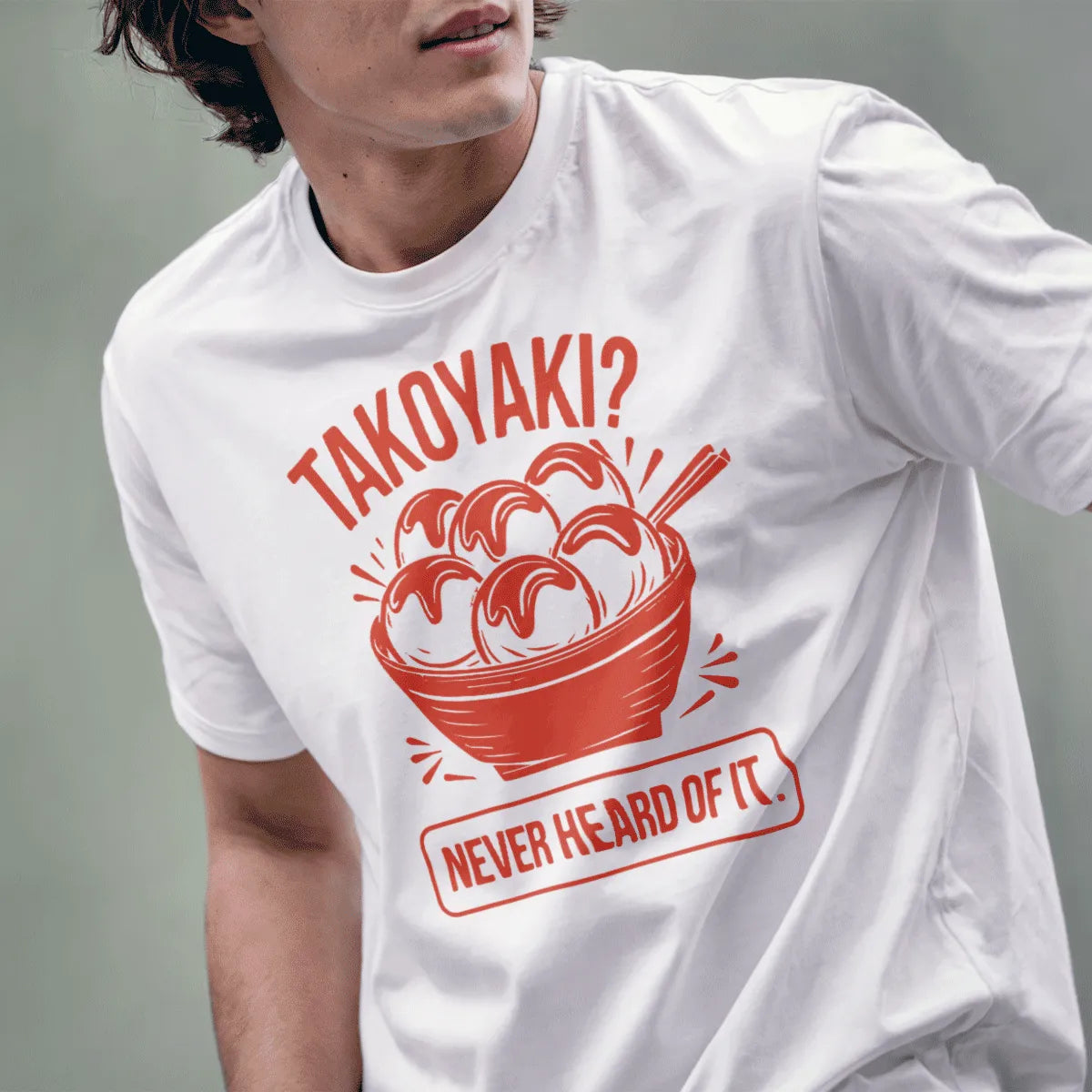 Male model wears white t-shirt with vibrant takoyaki graphic and humorous quote, showcasing streetwear style.