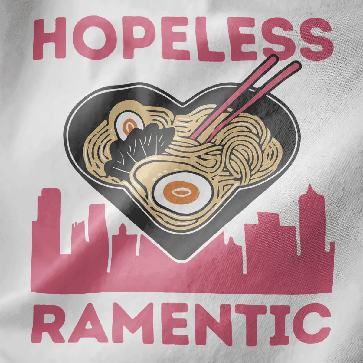 Heart-shaped ramen bowl with cityscape and pink lettering on white fabric, urban ramen, love symbolism.