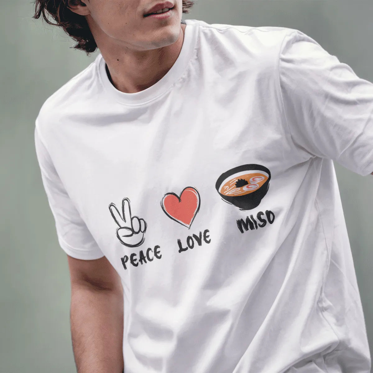 Male model in white t-shirt displaying Peace, Love, Miso design with hand-drawn icons celebrating Japanese culture.
