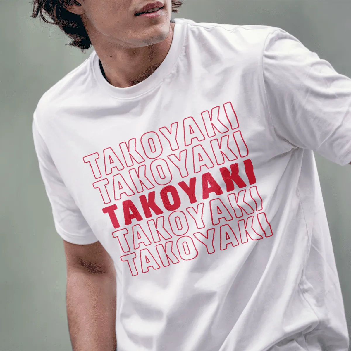 Male model wears white t-shirt with structured “TAKOYAKI” grid, red focal point, pop-art aesthetic.