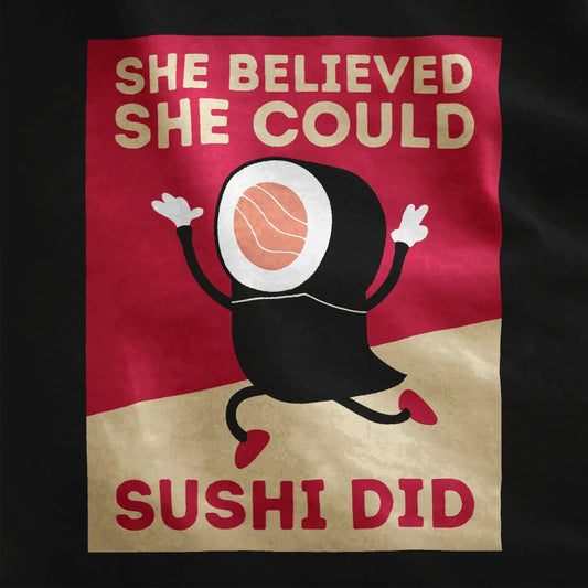 Close-up of black shirt with sushi roll character and “She Believed She Could Sushi Did” motivational quote.