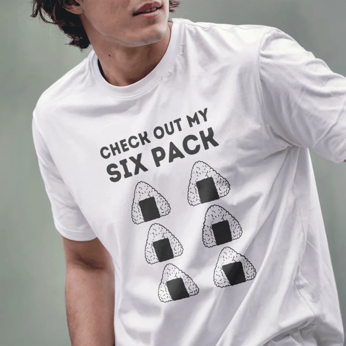 Male model in white t-shirt with onigiri six-pack and bold text; japanese t-shirts, humorous quote.