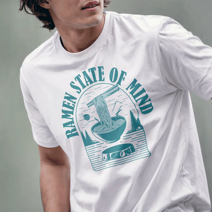 Male model wearing white t-shirt with teal ramen bowl, pine trees, and mountain, ramen t-shirt, motivational quote.