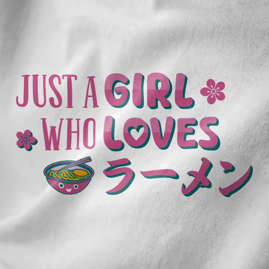White closeup of playful ramen shirt with pink and teal text, cherry blossoms, and a cute ramen bowl illustration.