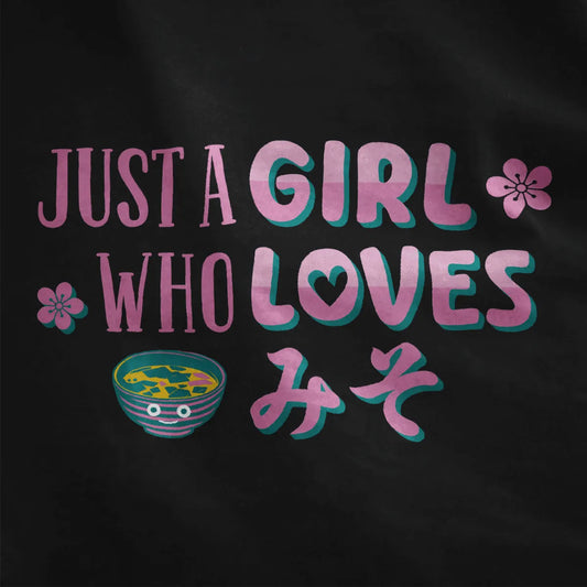Black closeup of kawaii clothes design with pink and teal text, sakura flowers, and cute miso soup bowl.