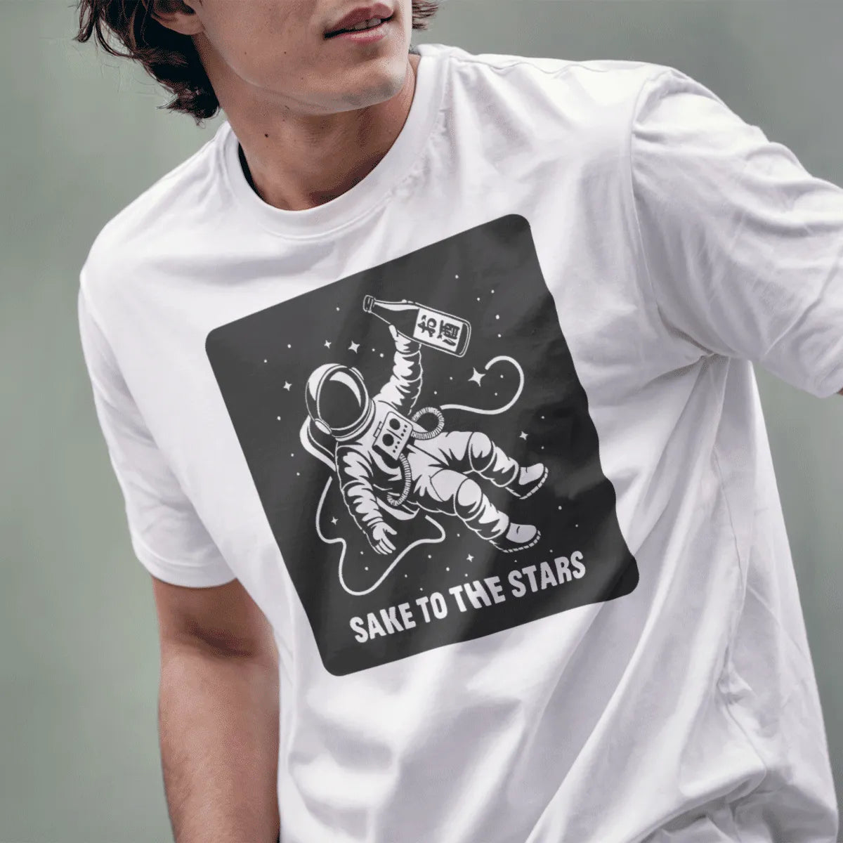 Male model in white t-shirt with astronaut and sake bottle, "SAKE TO THE STARS" text, japanese t-shirts, pop art shirt.