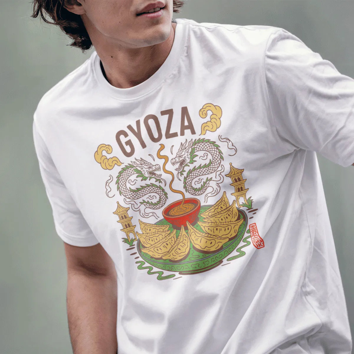 Male model in white gyoza t-shirt with dragon, clouds, and golden dumplings, inspired by traditional Japanese art.