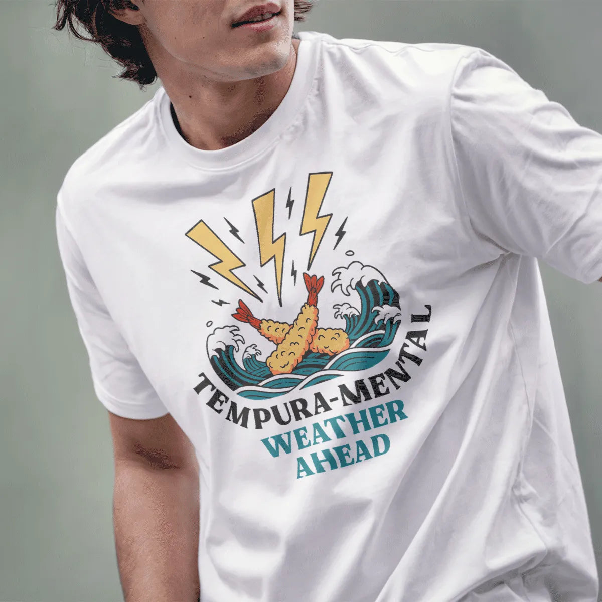 Male model in white t-shirt with cartoon tempura prawns, waves, and bold "Tempura-Mental" quote.