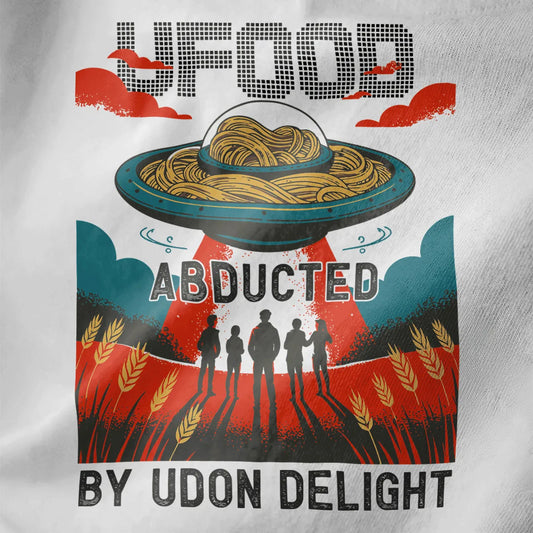 Close-up of white t-shirt fabric featuring retro pixel art UFO with udon noodles and bold arcade-style lettering.