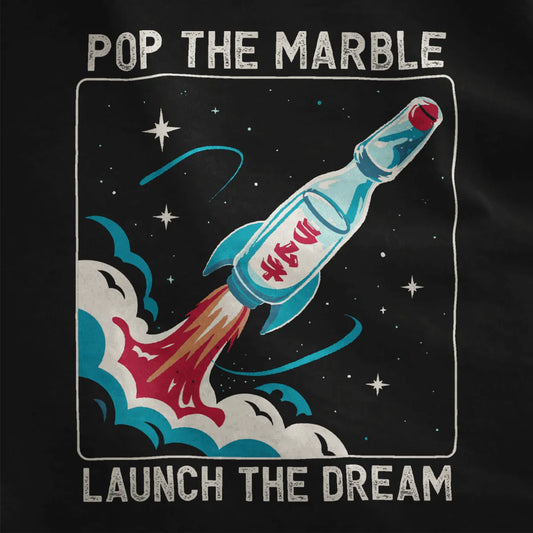 Black fabric close-up showing retro-futuristic Ramune rocket with Japanese characters and vibrant blue fins.