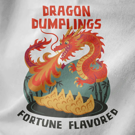 Close-up of white t-shirt fabric with fiery dragon, golden gyoza dumplings, and bold vintage lettering.